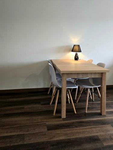 a wooden table with chairs and a lamp on top at Elandor Suite East Minissy Moka in Moka