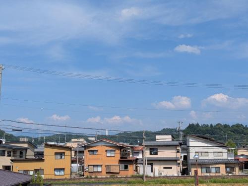 a group of houses in a city under a blue sky at Tabist Ryokufuen Kiyoharu in Takayama