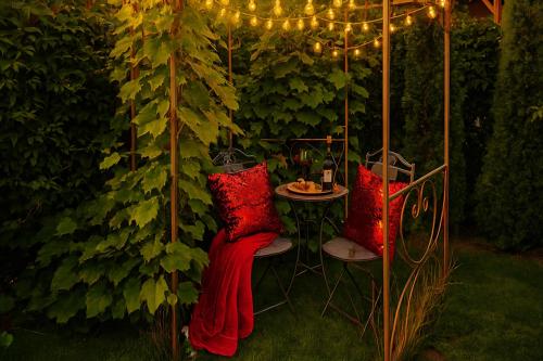 a garden with two chairs and a table with lights at Family Hotel in Daugavpils