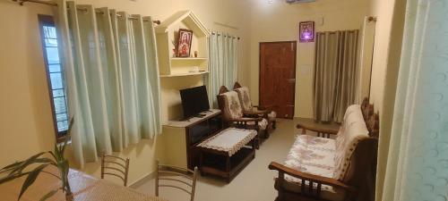 a living room with a desk with a computer and chairs at Skylark Homestay Panchalimedu in Pīrmed