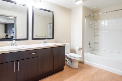 a bathroom with a sink and a toilet and a tub at Blueground Contra Costa Centre pool nr Walnut Creek Park SFO-1902 in San Francisco