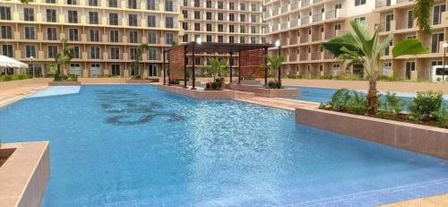 a large swimming pool in front of a building at Studio w pool, mountain city view Mactan airport in Basbas