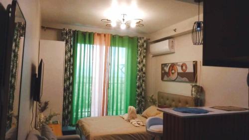 a bedroom with a bed and a green curtain at Studio w pool, mountain city view Mactan airport in Basbas