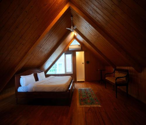 a bedroom with a bed and a window in a attic at Megha Resort & Villas, Dehradun-Where Nature Pampers You in Dehradun
