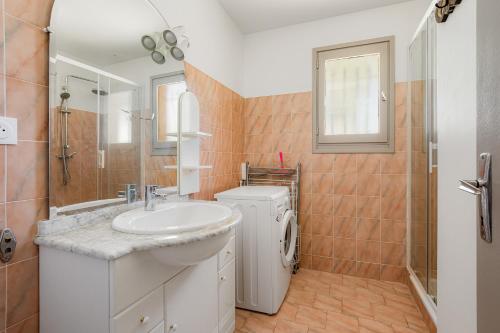 a bathroom with a sink and a washing machine at L'Oasis Occitane - Piscine Privée in Le Grau-dʼAgde