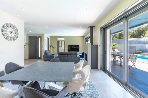 a living room with a table and chairs at La Villa Grazzoso - Piscine Privée in Sainte-Lucie de Porto-Vecchio