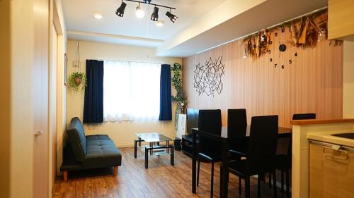 a living room with a table and chairs and a kitchen at Brand new mansion in Maruyama - Nekogoya Maruyama in Sapporo