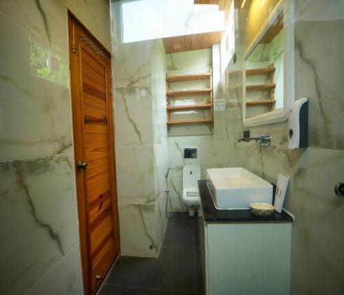 a small bathroom with a sink and a toilet at Megha Resort & Villas, Dehradun-Where Nature Pampers You in Dehradun