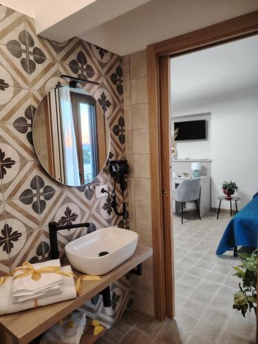 a bathroom with a sink and a mirror on a wall at Stella del Rio in Naro