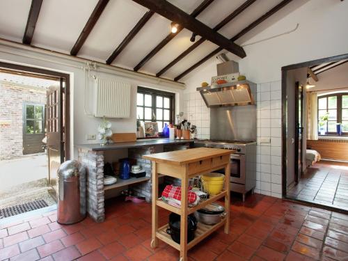 a kitchen with a wooden table in a room at Farmhouse in Sint Joost with Pool & BBQ in Sint Joost