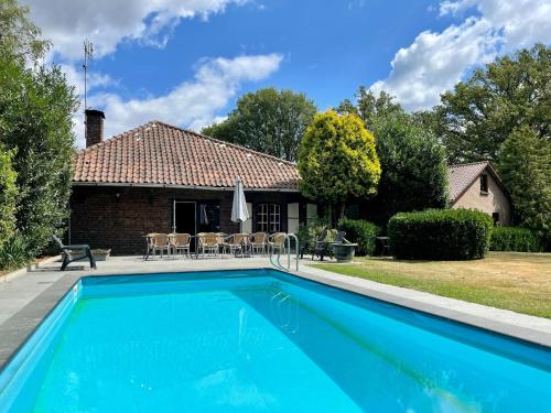 a swimming pool in front of a house at Farmhouse in Sint Joost with Pool & BBQ in Sint Joost