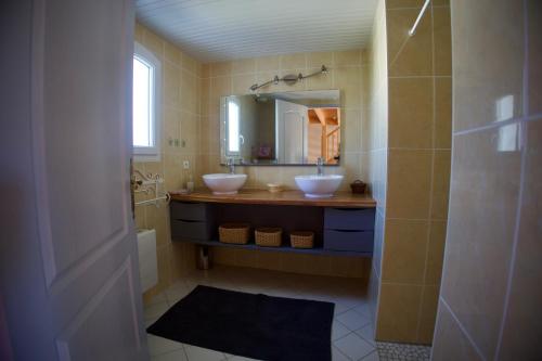 ein Badezimmer mit zwei Waschbecken und einem Spiegel in der Unterkunft La Galidolle, au calme à 5 minutes de la plage in La Guérinière