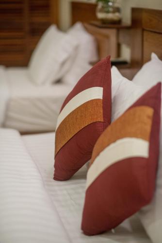 two brown and white pillows on a bed at Reasey Boutique Villa in Siem Reap