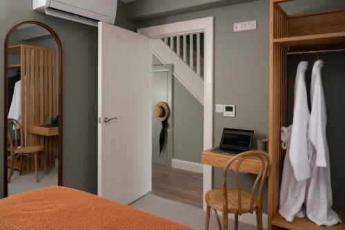 a bedroom with a bed and a desk and a staircase at The Salthouse Hotel in Ballycastle
