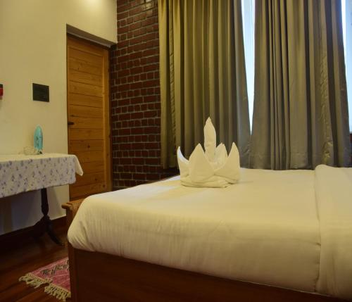 a bedroom with a bed with white flowers on it at Megha Resort & Villas, Dehradun-Where Nature Pampers You in Dehradun