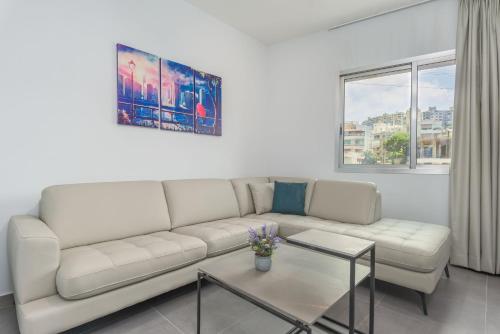 a living room with a couch and a table at Grey - Elegant Apartments in Awkar in Dbayeh
