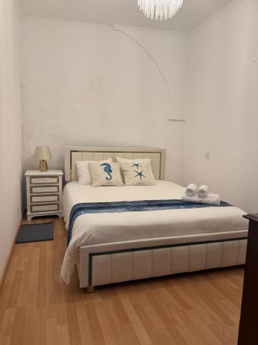 a bedroom with a bed with white sheets and a chandelier at Casa Chil in Olhão