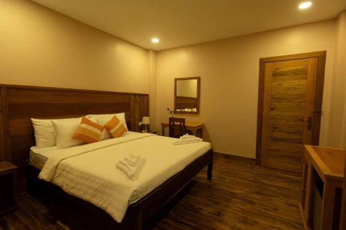 a bedroom with a bed with two towels on it at Reasey Boutique Villa in Siem Reap