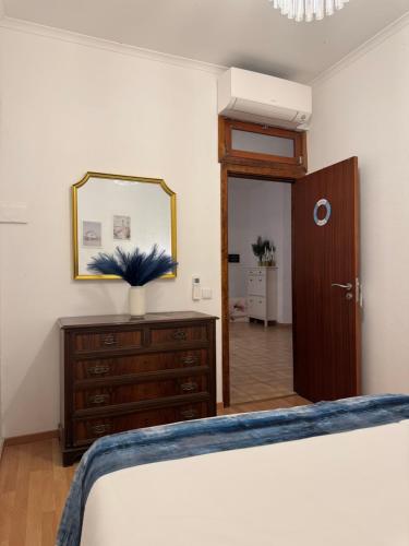 a bedroom with a bed and a mirror and a dresser at Casa Chil in Olhão