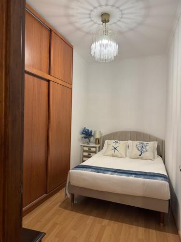 a bedroom with a bed and a chandelier at Casa Chil in Olhão