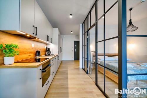a kitchen with a sink and a bed in a room at Apartamenty BalticON Polanki Aqua in Kołobrzeg