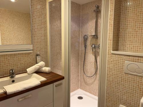 a bathroom with a shower and a sink at Le Trophée Boutique Hôtel Spa- La Loggia Appart'hôtel in Deauville