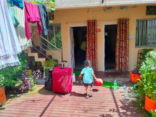a little boy walking out of a house with a ball at Divine view - 1 bhk AC - Swarna Bhavan in Puri
