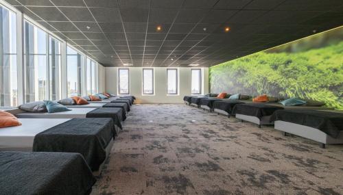 a row of beds in a room with windows at Fletcher Wellness-Hotel Leiden in Leiden