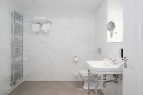 a white bathroom with a sink and a toilet at The Salthouse Hotel in Ballycastle