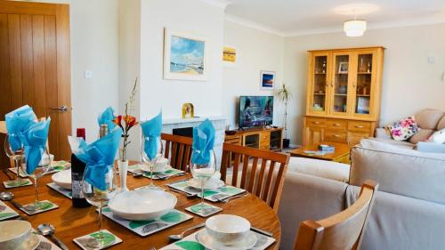 a dining room with a table with chairs and a couch at Ideal Family Holiday home Exmouth in Exmouth