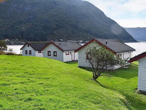 a row of houses on a hill next to a body of water at 5 person holiday home in Selje-By Traum in Selje