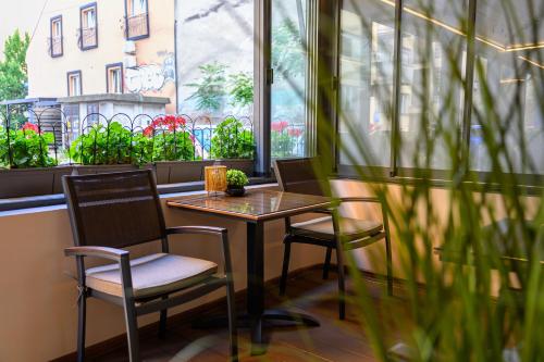 a table and two chairs in front of a window at Garni Hotel Zenit in Novi Sad