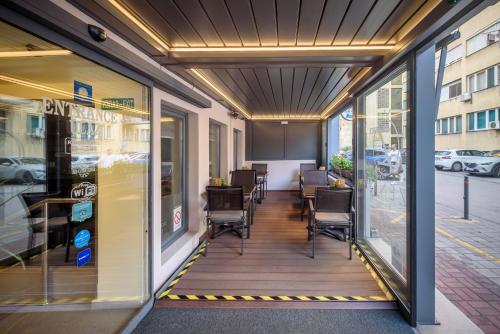 a walkway in a store front with chairs and windows at Garni Hotel Zenit in Novi Sad