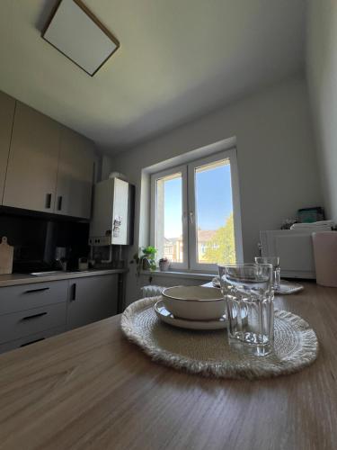 アルバ・ユリアにあるSunset Apartmentsのキッチン(皿とガラスのテーブル付)