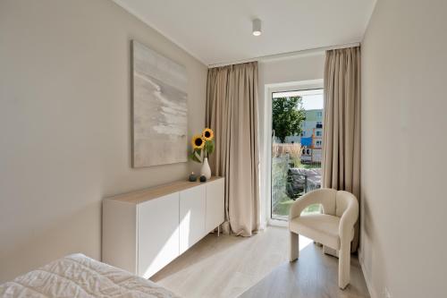 a bedroom with a bed and a chair and a window at Casa Baia BlueApart Hel in Hel