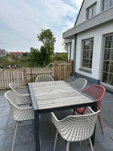 a wooden table and chairs on a patio at Z' Evita in Nieuwpoort