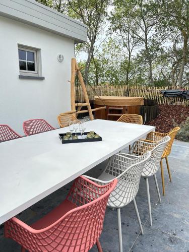 a white table and chairs with wine glasses on it at Z' Evita in Nieuwpoort
