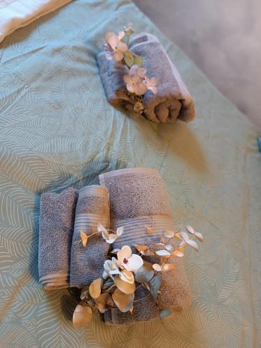 two towels with flowers on them on a bed at La Mansardina di Sabrina in Busca