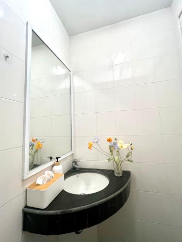 a bathroom with a sink and a mirror at Nomad Stay Hostel with Coworking Space in Amphoe Koh Samui
