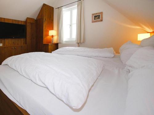 a bedroom with two beds with white sheets and a window at Semi-detached houses, turf house in Torfhaus