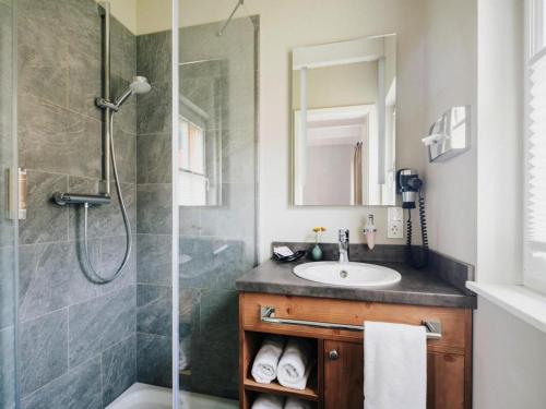 a bathroom with a shower and a sink at Semi-detached houses, turf house in Torfhaus