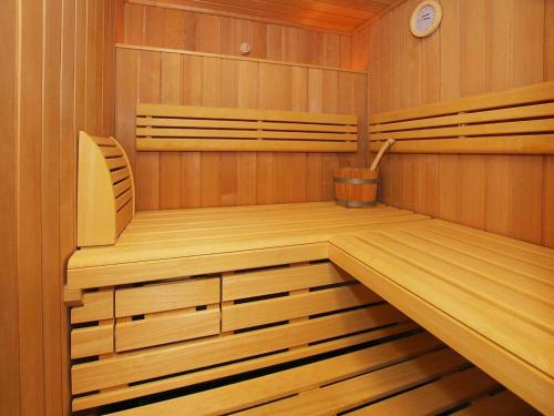 a sauna with a bench and a clock in it at Semi-detached houses, turf house in Torfhaus