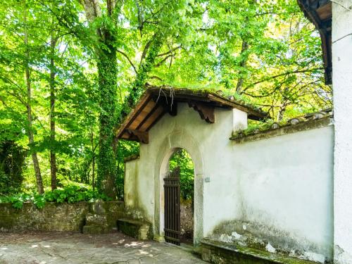 a building with a gate in the middle of a forest at Holiday Home with Garden and shared pool in Migliorini