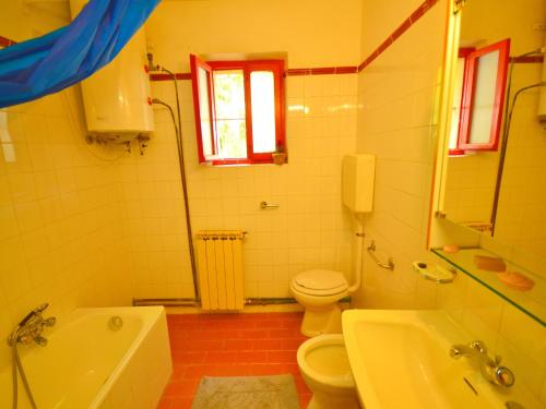 a bathroom with a toilet and a tub and a sink at Holiday Home with Garden and shared pool in Migliorini
