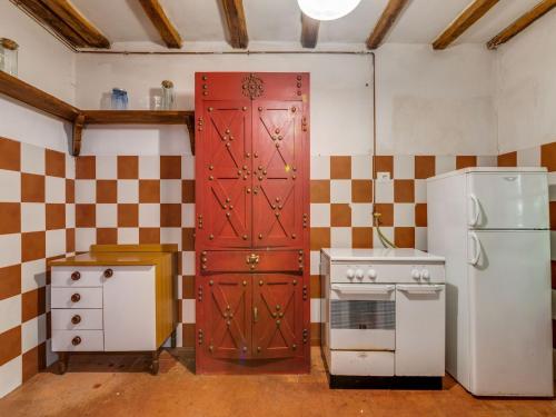 a kitchen with a red door and a stove at Holiday Home with Garden and shared pool in Migliorini