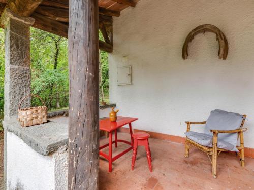 a red table and a chair on a porch at Holiday Home with Garden and shared pool in Migliorini
