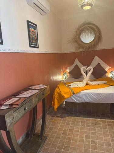 a bedroom with a bed and a table in it at Riad Dihya in Marrakech