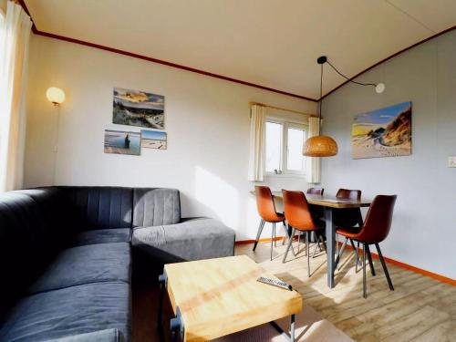 a living room with a couch and a table at Inviting Dune Chalet in Hollum near Golf Course in Hollum