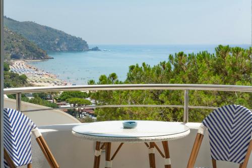 a table and chairs on a balcony with a view of the ocean at Vento Verde Apartments in Sperlonga