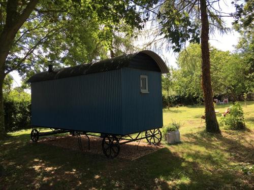 a blue shed on a cart in a park at The Scrumpy Shepherd, Brandeston in Cretingham